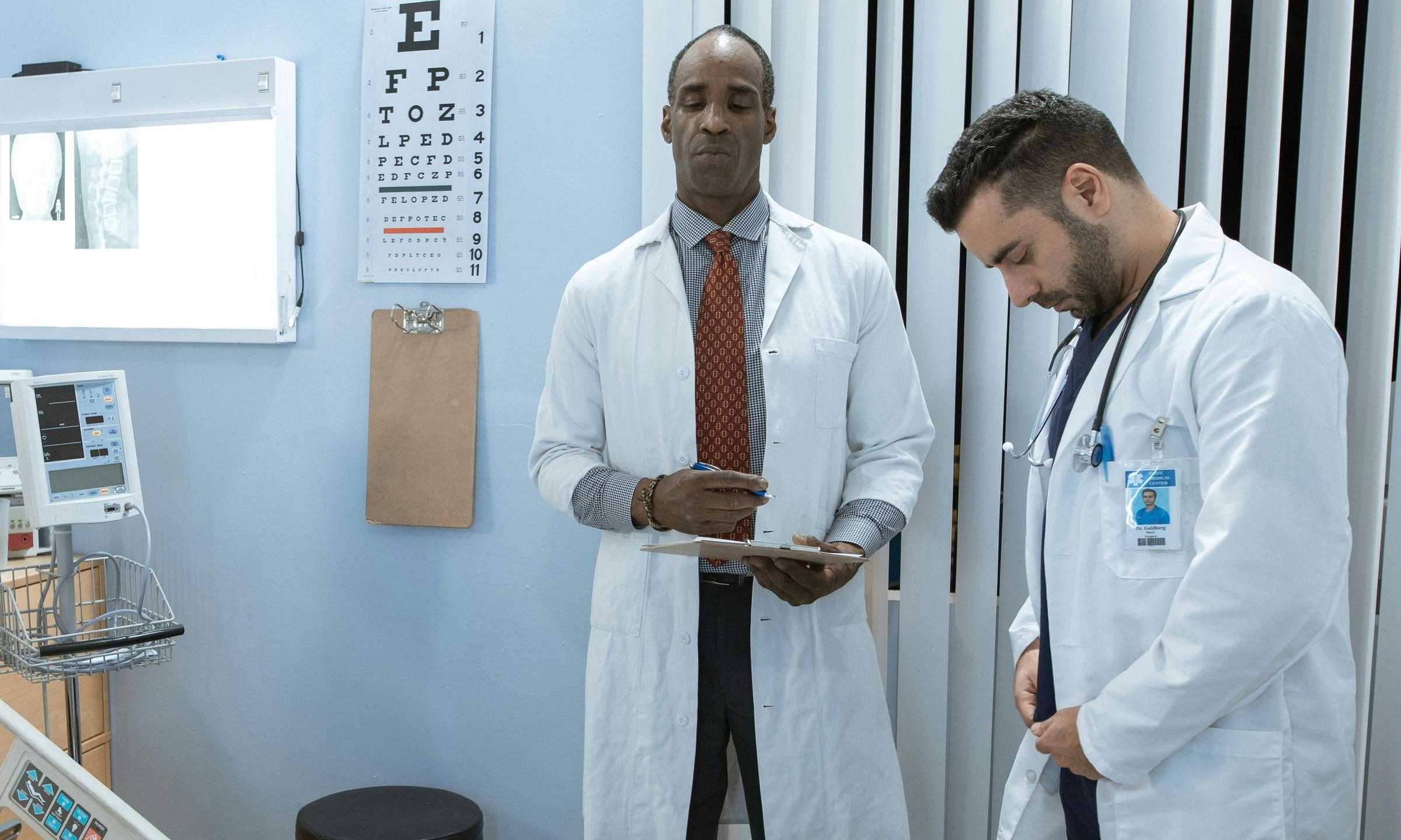 Doctors standing beside a hospital bed, looking concerned | Source: Pexels